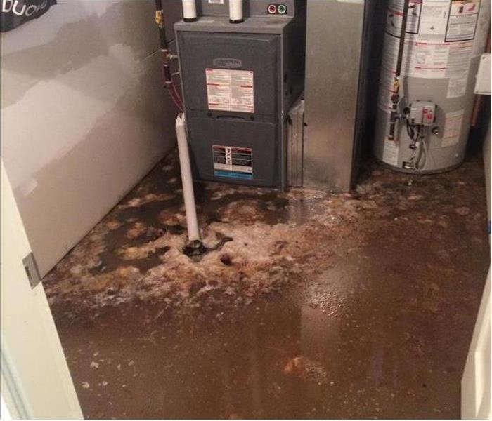 muddy floodwater lapping a a furnace in a basement