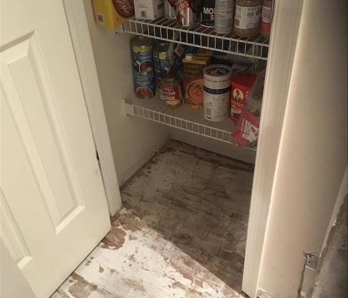 removed boards, showing subfloor in the pantry for drying